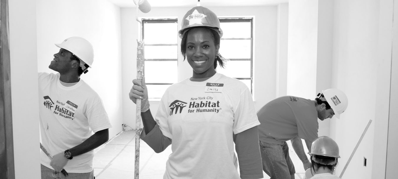 An on-site volunteer stands with a paint roller