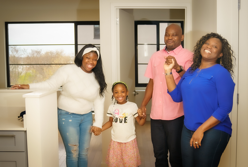 Photo of a family of four inside their new home in the Bronx